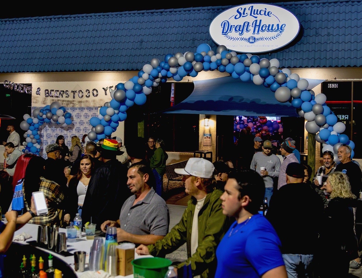 Crowded night event with balloon decor installation